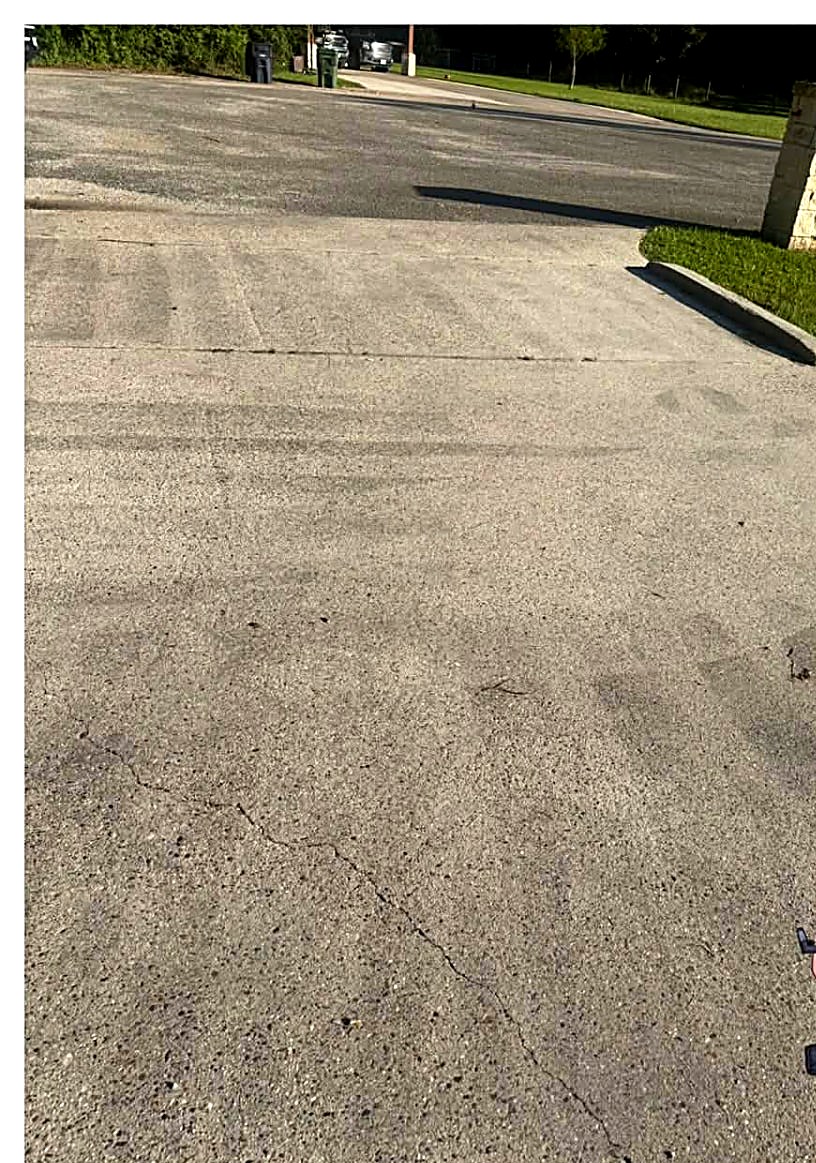 Stained residential concrete driveway before pressure washing
