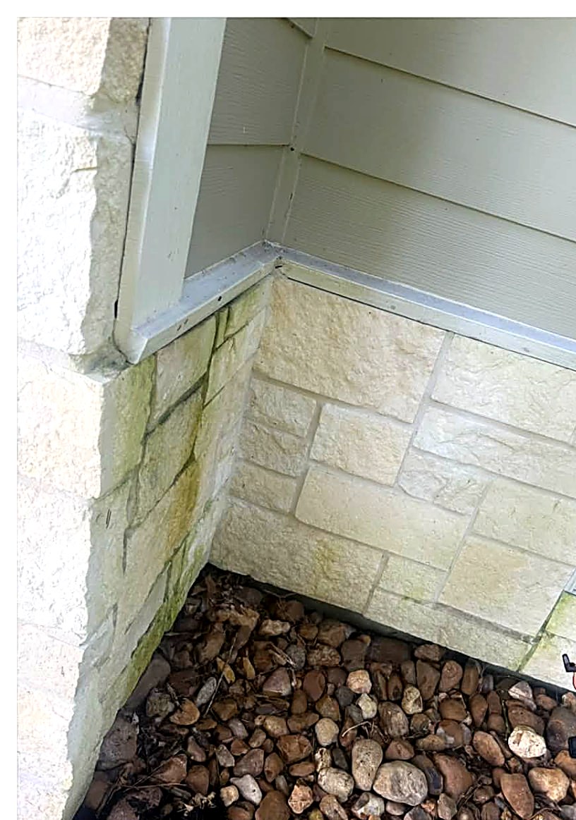 Green algae buildup on stone veneer and siding before washing